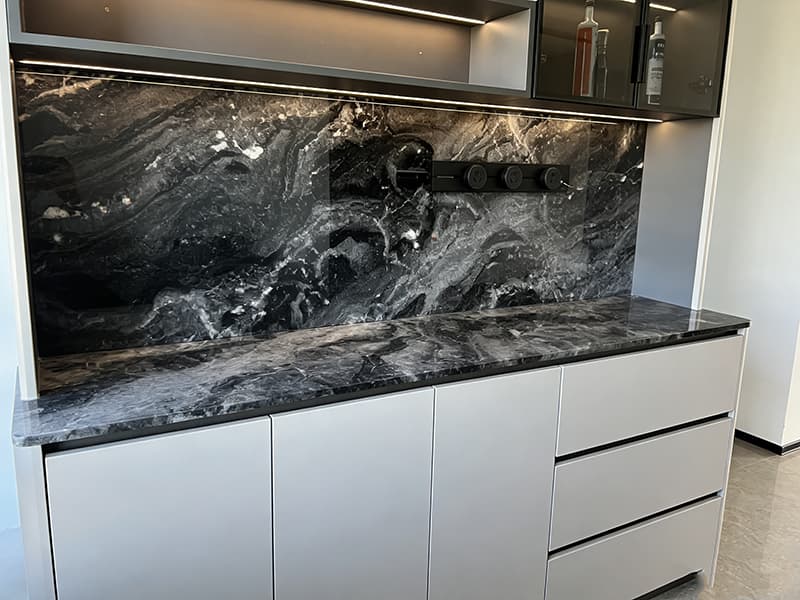 Black marble kitchen countertop and backlit marble backsplash paired with gray modern cabinetry – sleek contemporary kitchen surface.jpg
